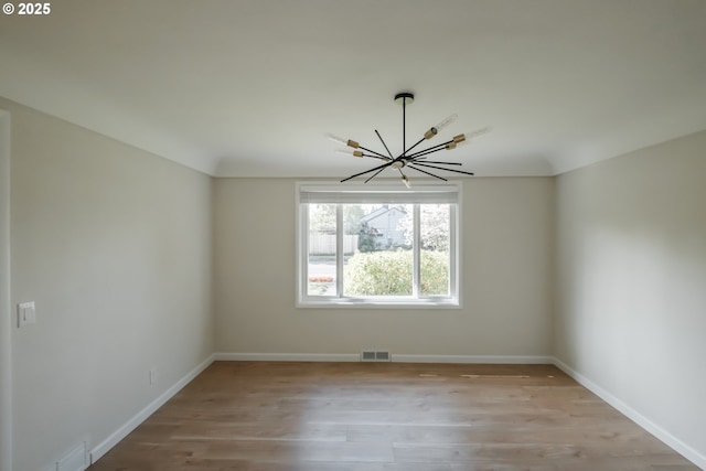 unfurnished dining area with baseboards, visible vents, wood finished floors, and an inviting chandelier