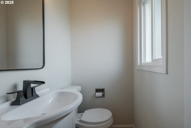bathroom with baseboards, toilet, and vanity