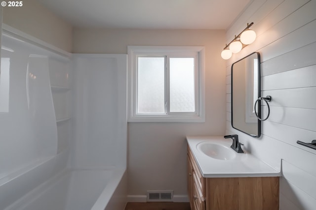 full bathroom with baseboards, visible vents, tub / shower combination, and vanity