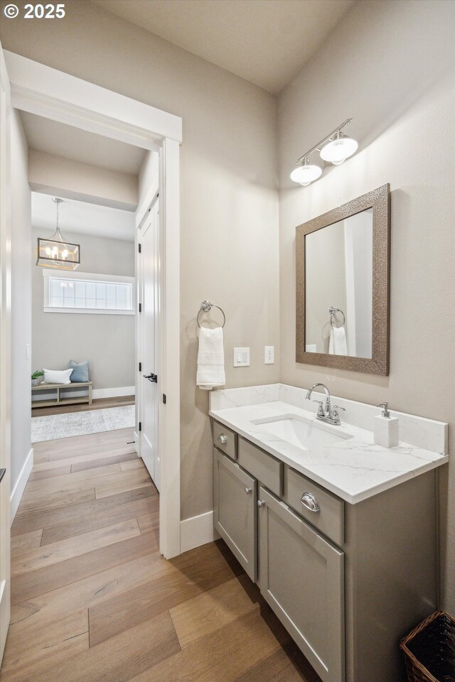 2625 SE Vineyard Way, Milwaukie, OR 97267 - bathroom featuring wood finished floors, vanity, a chandelier, and baseboards