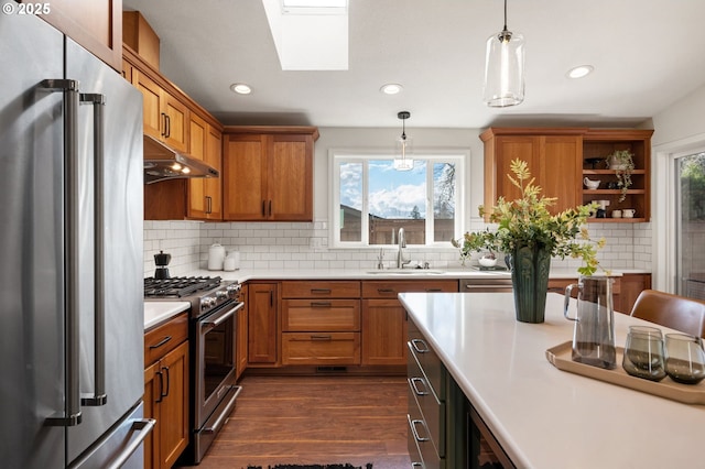 kitchen featuring high end appliances, dark wood-style flooring, a sink, light countertops, and under cabinet range hood