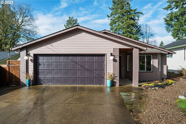 single story home with a garage, concrete driveway, and fence