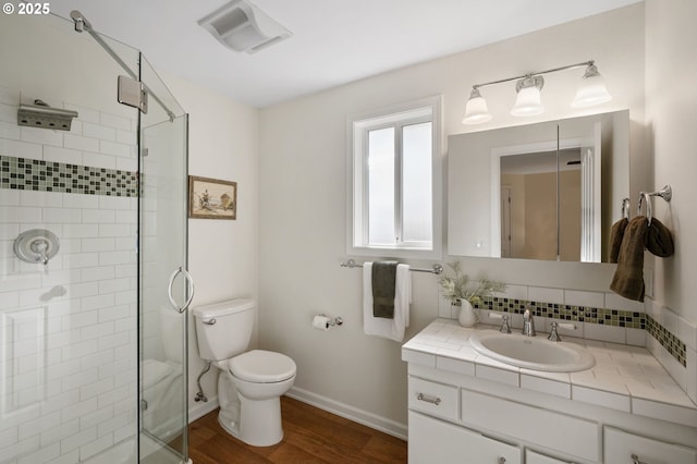 bathroom featuring visible vents, a shower stall, toilet, decorative backsplash, and wood finished floors