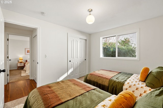 bedroom featuring a closet, baseboards, and wood finished floors