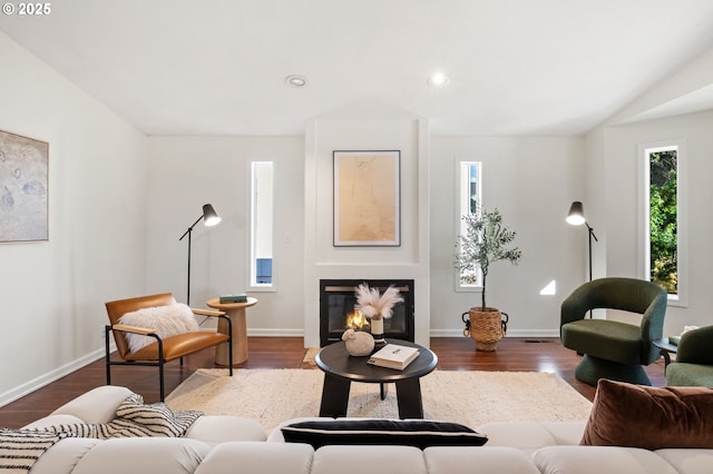 living area featuring a glass covered fireplace, baseboards, wood finished floors, and recessed lighting