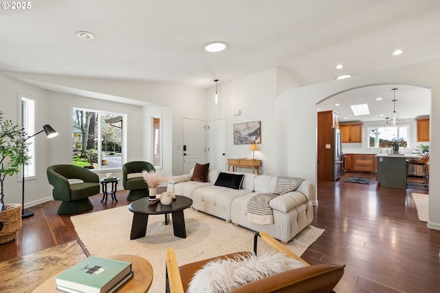 living room with recessed lighting, baseboards, arched walkways, and dark wood-style flooring