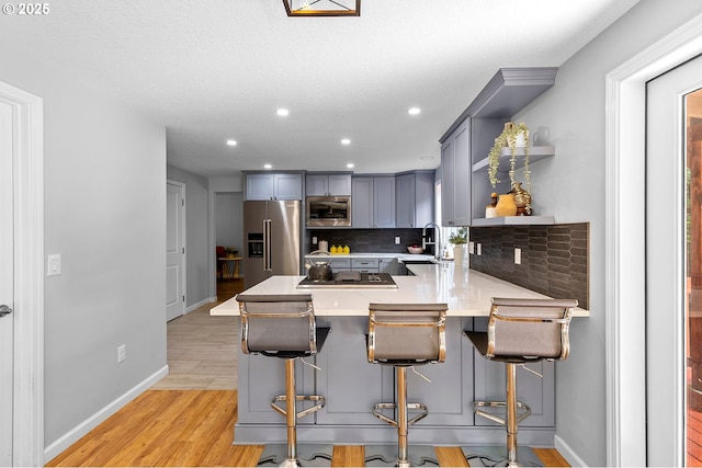 2111 NE 149th Ave, Vancouver, WA 98684 - kitchen with stainless steel appliances, gray cabinets, open shelves, a peninsula, and backsplash