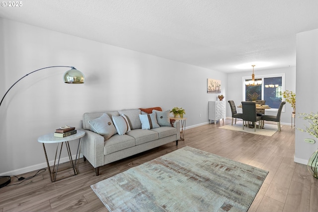 2111 NE 149th Ave, Vancouver, WA 98684 - living area featuring a chandelier, wood finished floors, baseboards, and a textured ceiling