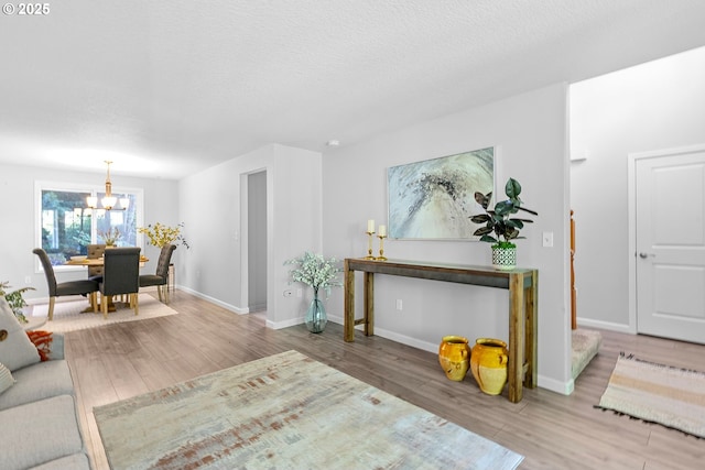 2111 NE 149th Ave, Vancouver, WA 98684 - living room with a chandelier, wood finished floors, baseboards, and a textured ceiling