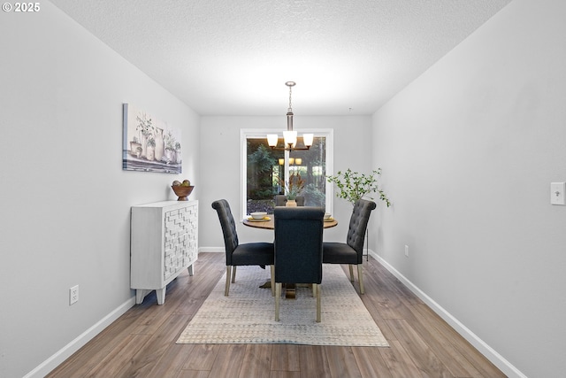 2111 NE 149th Ave, Vancouver, WA 98684 - dining room with a chandelier, wood finished floors, baseboards, and a textured ceiling
