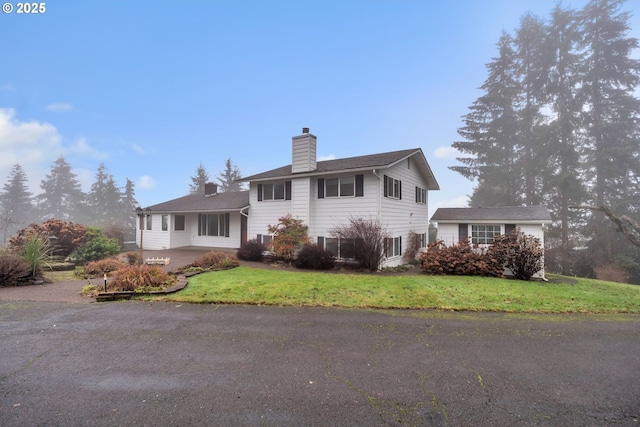 view of front of home with a patio and a front lawn