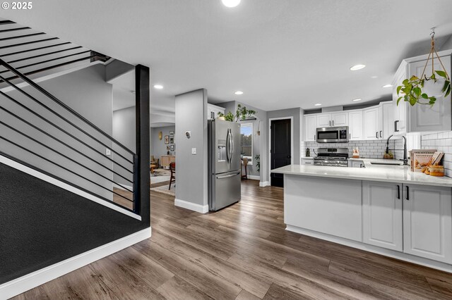 10417 NE 86th Ave, Vancouver, WA 98662 - kitchen with appliances with stainless steel finishes, a peninsula, white cabinetry, dark wood-type flooring, and tasteful backsplash