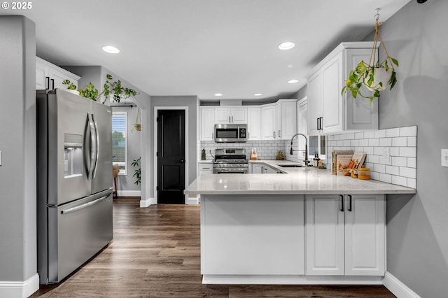 10417 NE 86th Ave, Vancouver, WA 98662 - kitchen with stainless steel appliances, a peninsula, white cabinets, decorative backsplash, and recessed lighting
