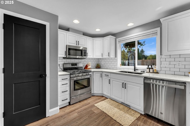 10417 NE 86th Ave, Vancouver, WA 98662 - kitchen with appliances with stainless steel finishes, white cabinetry, decorative backsplash, recessed lighting, and light wood-style floors