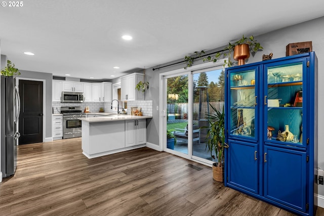 10417 NE 86th Ave, Vancouver, WA 98662 - kitchen with appliances with stainless steel finishes, a peninsula, dark wood finished floors, white cabinetry, and light countertops