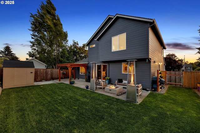 10417 NE 86th Ave, Vancouver, WA 98662 - back of house at dusk with a patio, a fire pit, a storage unit, and a fenced backyard