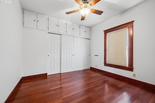 2309 7th St, Tillamook, OR 97141 - unfurnished bedroom featuring dark wood-style flooring, baseboards, a closet, and ceiling fan