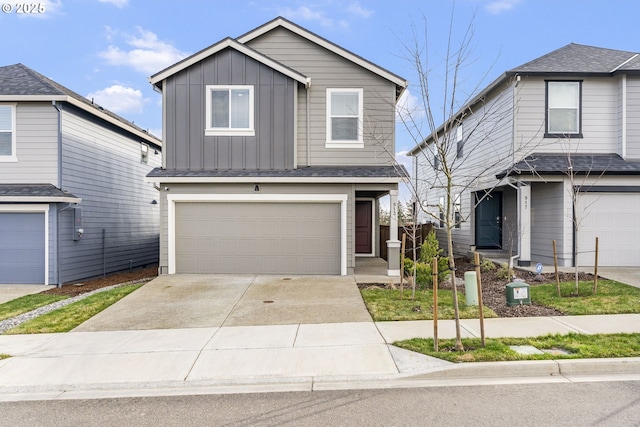 traditional-style house with a garage, concrete driveway, and board and batten siding