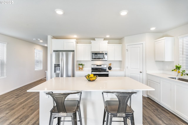 kitchen featuring a center island, stainless steel appliances, recessed lighting, a sink, and a kitchen breakfast bar