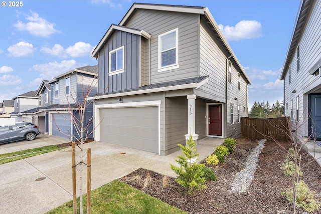 view of front of property with a garage, concrete driveway, board and batten siding, and fence