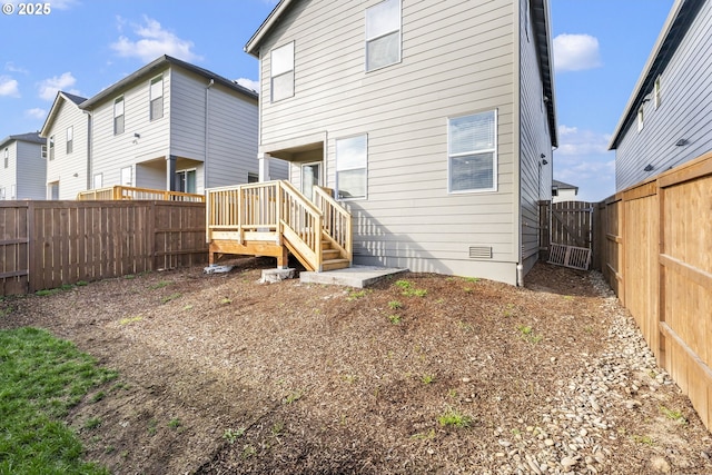 rear view of property with crawl space, a fenced backyard, and a gate