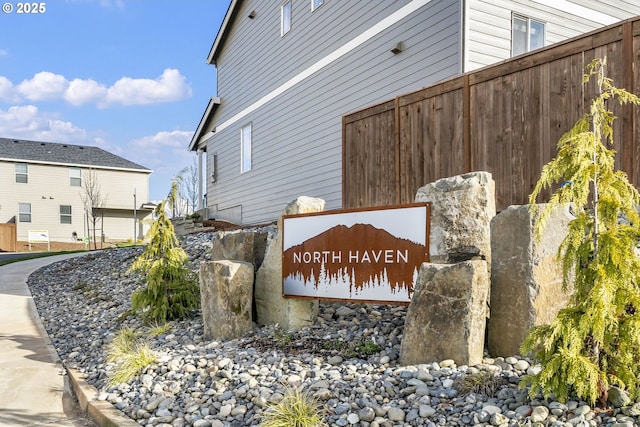 community / neighborhood sign featuring fence