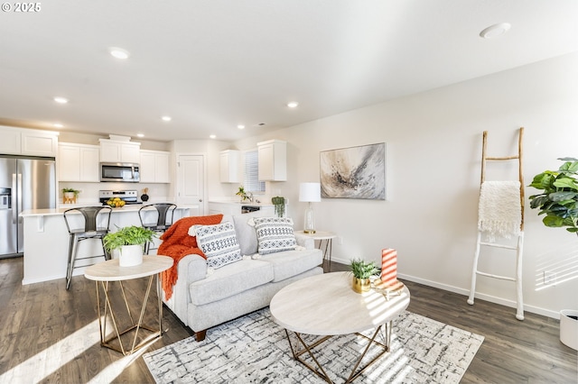 living room featuring baseboards, dark wood finished floors, and recessed lighting