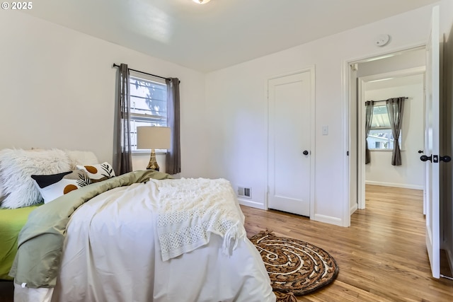 6540 SE 88th Ave, Portland, OR 97266 - bedroom with multiple windows, light wood-style floors, and baseboards