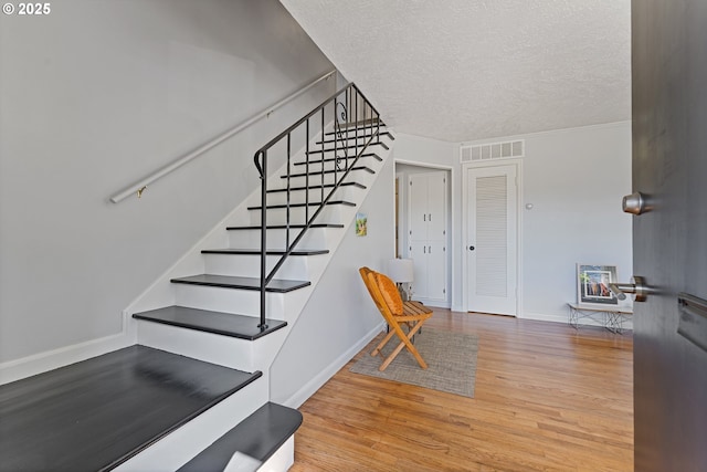 6540 SE 88th Ave, Portland, OR 97266 - stairs featuring wood finished floors, a textured ceiling, and baseboards