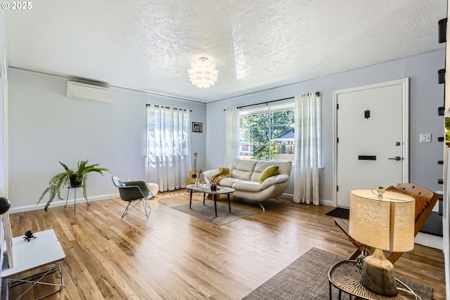 6540 SE 88th Ave, Portland, OR 97266 - living area featuring an AC wall unit, a textured ceiling, wood finished floors, and baseboards
