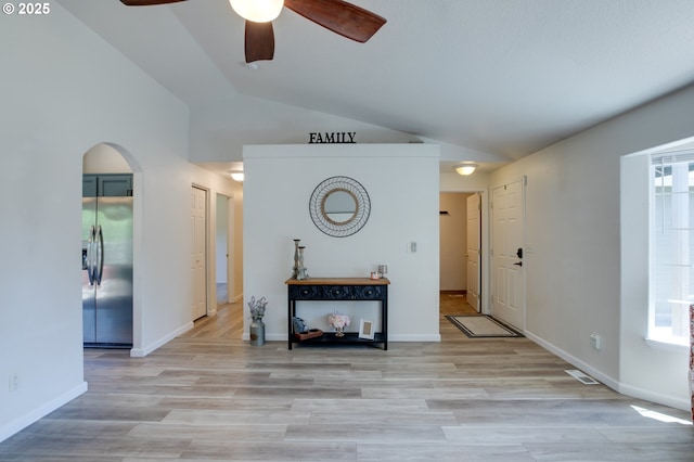 1185 Shady Ln, Keizer, OR 97303 - living room featuring vaulted ceiling, ceiling fan, arched walkways, and light wood-style floors