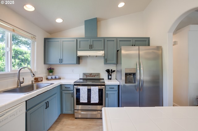 1185 Shady Ln, Keizer, OR 97303 - kitchen with stainless steel appliances, under cabinet range hood, lofted ceiling, tile countertops, and arched walkways