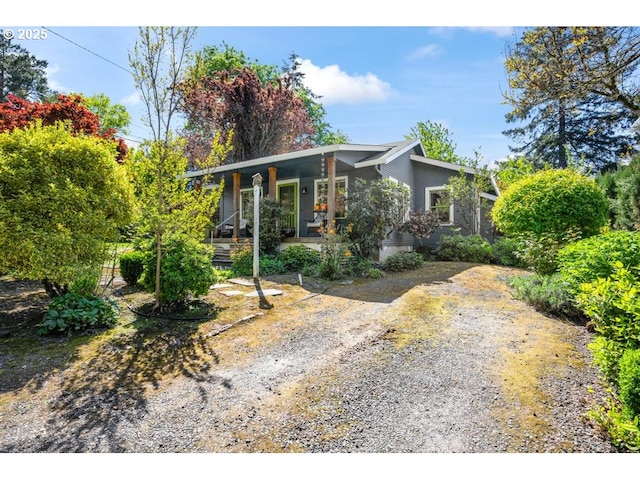 view of front facade with a porch and gravel driveway