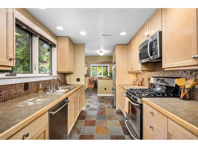kitchen with a sink, appliances with stainless steel finishes, and light brown cabinets