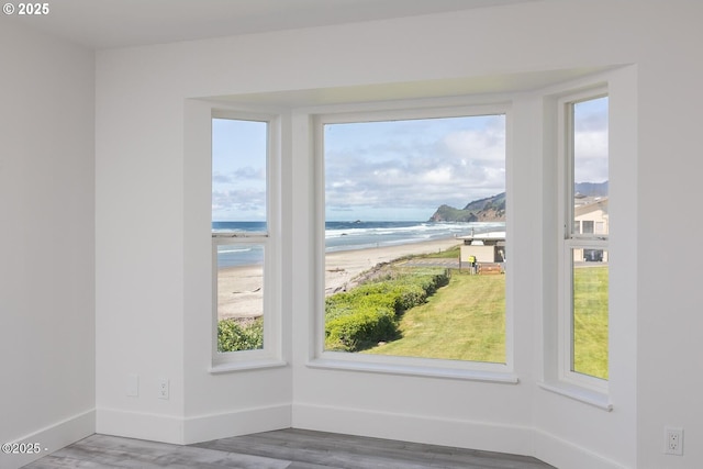 3929 NW Jetty Ave Unit 5, Lincoln City, OR 97367 - spare room with view of water and beach, wood finished floors, and baseboards
