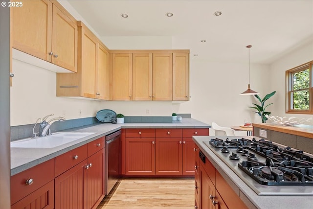 4908 SW Barnes Rd, Portland, OR 97221 - kitchen with stainless steel appliances, a sink, light wood-type flooring, light countertops, and decorative light fixtures