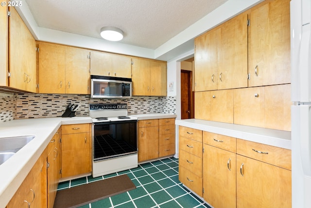 kitchen featuring electric range oven, white refrigerator, sink, a textured ceiling, and tasteful backsplash