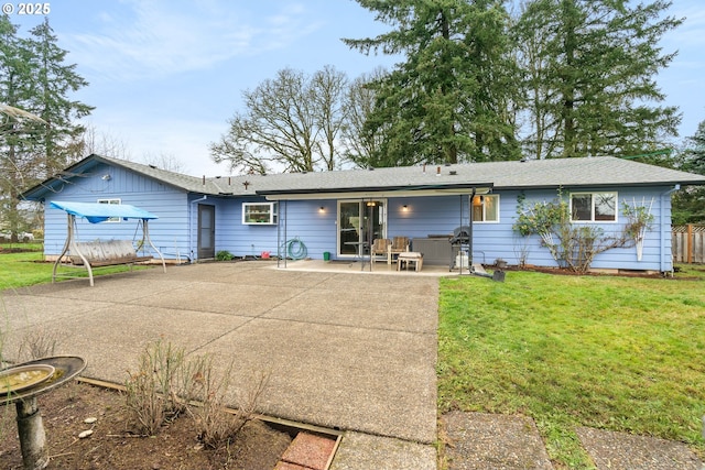 rear view of house with a patio and a lawn