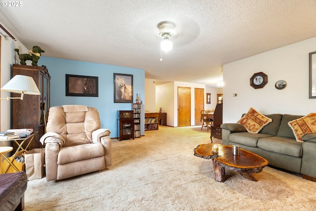 living room featuring a textured ceiling, ceiling fan, and carpet