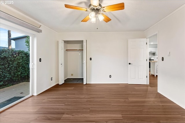 unfurnished bedroom featuring ornamental molding, access to outside, baseboards, and wood finished floors