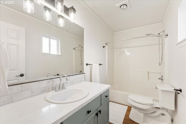 bathroom with bathtub / shower combination, toilet, ornamental molding, vanity, and wood finished floors