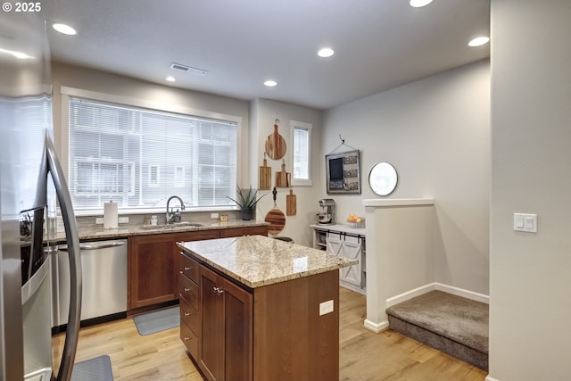 kitchen featuring a sink, light wood-style floors, a kitchen island, appliances with stainless steel finishes, and recessed lighting