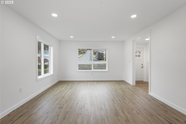 unfurnished room featuring baseboards, wood finished floors, and recessed lighting