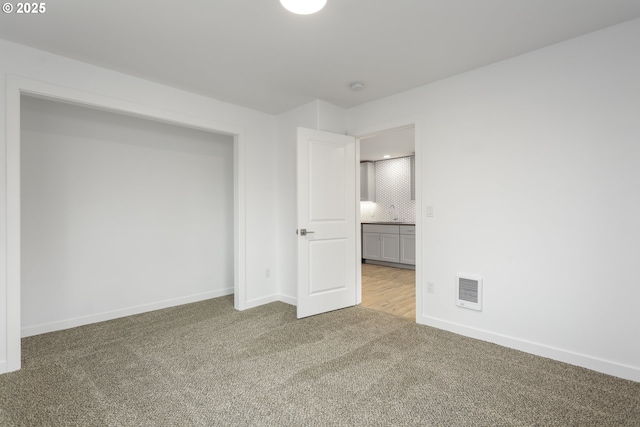 unfurnished bedroom featuring carpet, visible vents, and baseboards