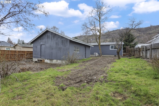 rear view of house featuring fence and a lawn