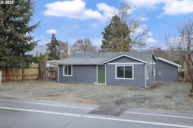 view of front of house with roof with shingles and fence