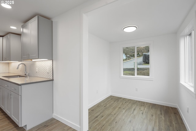 kitchen with a healthy amount of sunlight, a sink, and decorative backsplash