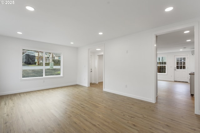 unfurnished room with a wealth of natural light, recessed lighting, and wood finished floors