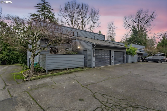 view of garage at dusk