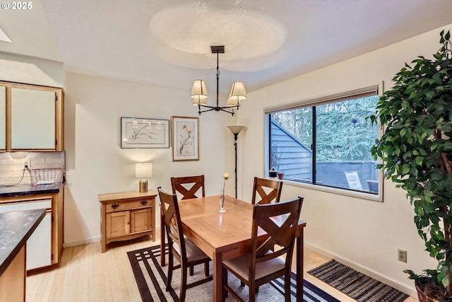 dining room featuring light wood-type flooring and a notable chandelier